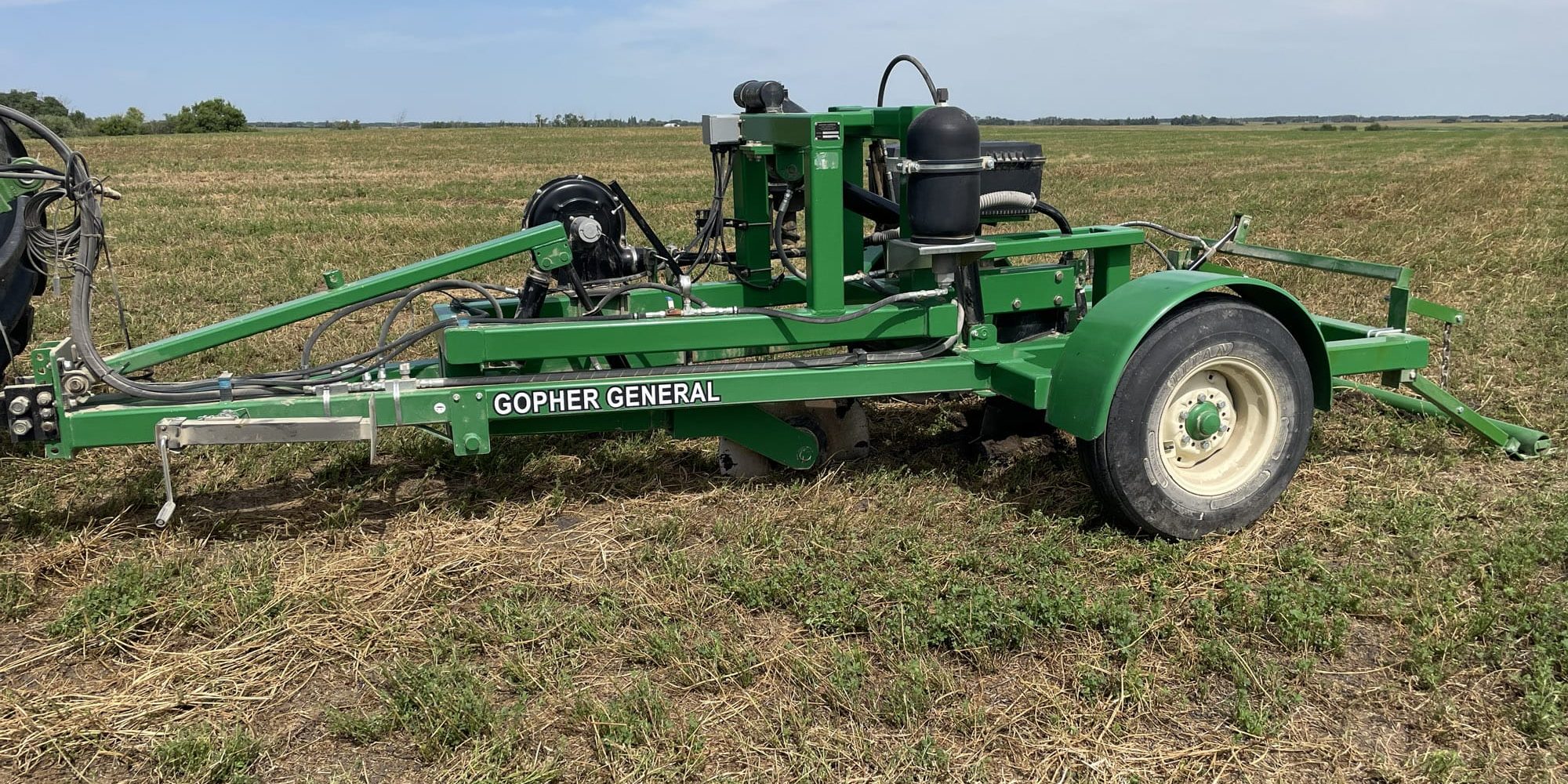 Green Gopher General agricultural implement parked in a field
